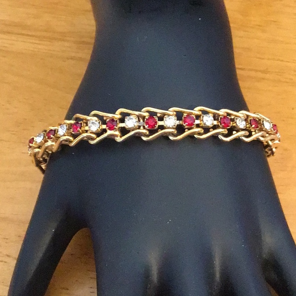 Gold tone bracelet with red and clear rhinestones.